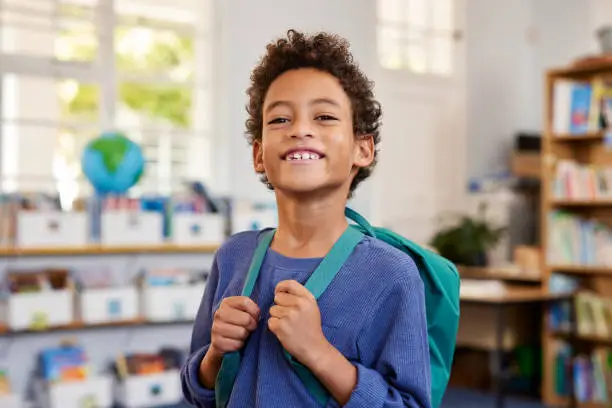 Happy boy with backpack ready for school learning phonics online
